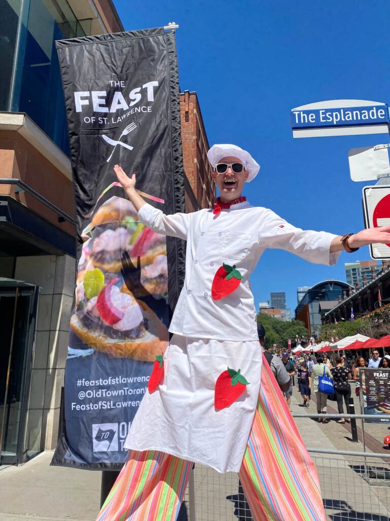 Chef on stilts Darren Bradford is wearing a white coat with large felt strawberries attached.