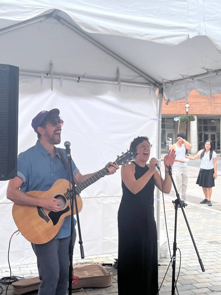 Jeremy Voltz and Gianna Antonacci play and sing under the tent at Market Street Stage 2023