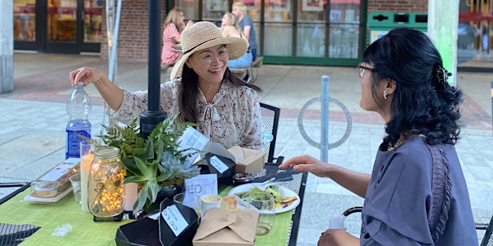 Two women share a delicious and elaborate picnic meal